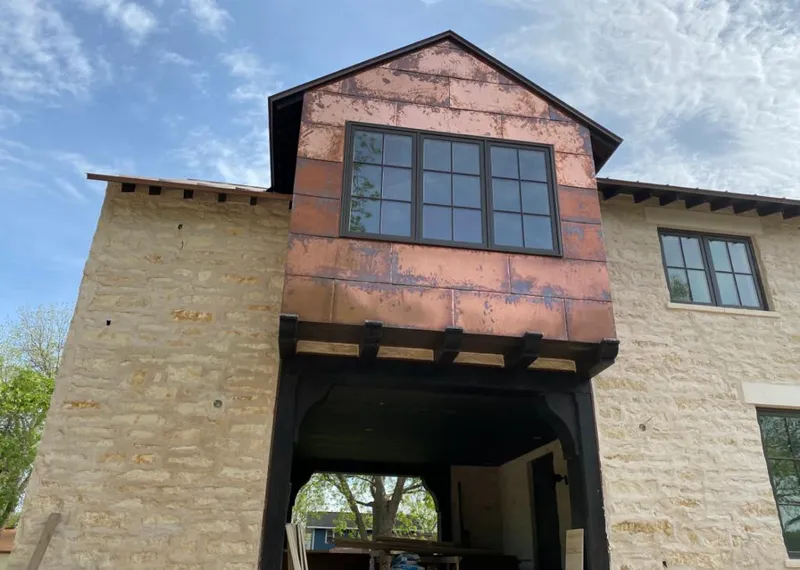Copper metal panel facade on a stone building for Skylight Installation in Faribault