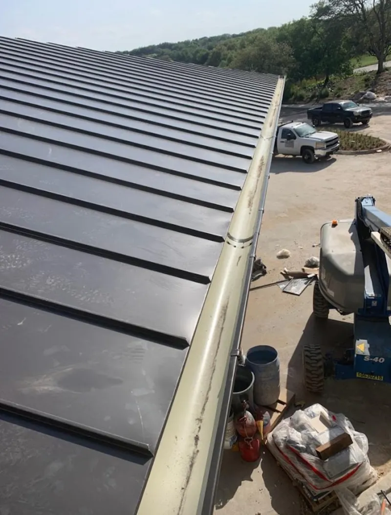 Standing seam panel and gutter detail on a metal roofing jobsite in Faribault